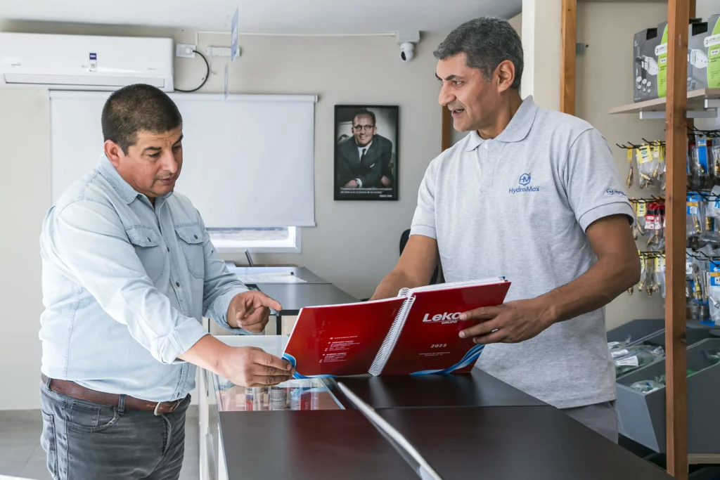Asesor de Hydromax mostrando un catálogo de productos a un cliente en el local de Tucumán